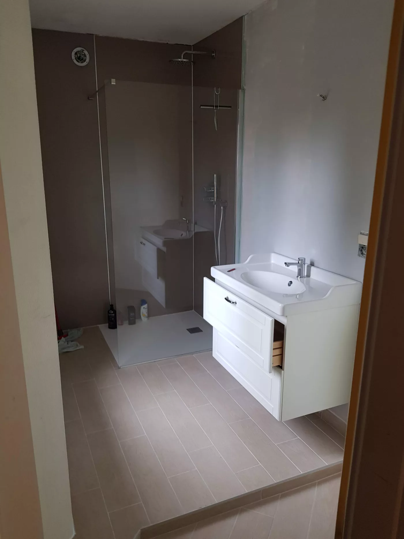 Salle de bains avec douche, paroi en verre et meuble vasque blanc
